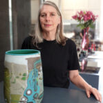 Woman holding large abstract ceramic vase indoors