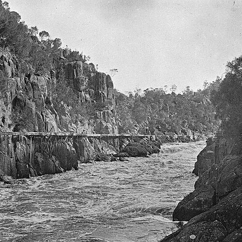 Wooden trestle bridge over rocky river gorge