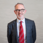 Smiling man in suit with red striped tie