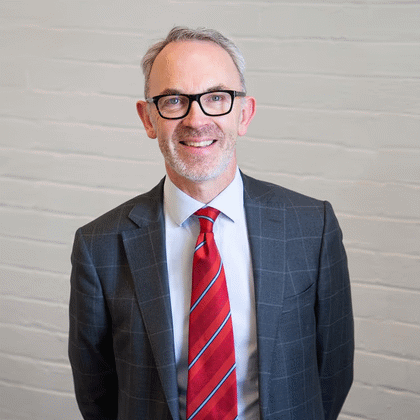 Smiling man in suit with red striped tie
