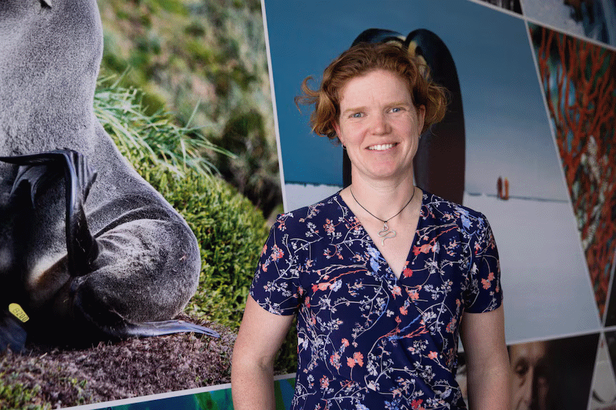 Woman standing in front of large photo prints