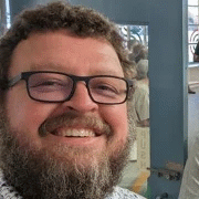 Smiling bearded man wearing glasses indoors