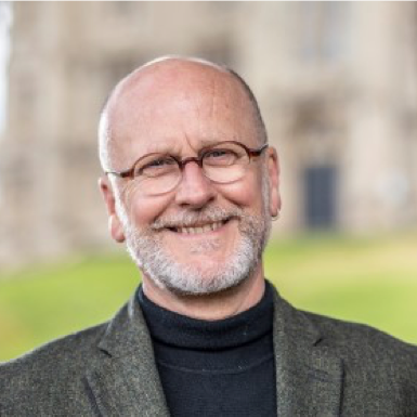 Smiling bald man with glasses outdoors