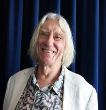 Smiling person in floral shirt and white jacket