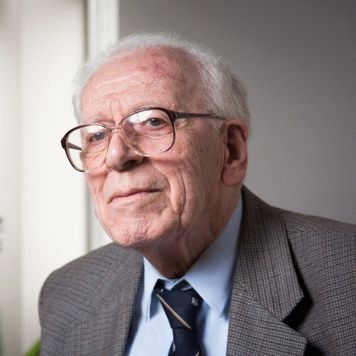 Elderly man wearing glasses and suit jacket