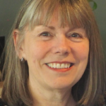 Smiling woman with shoulder-length hair and bangs